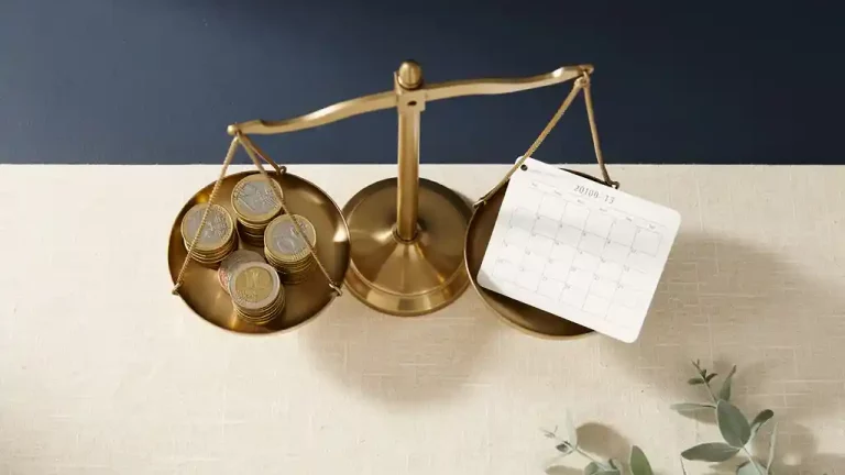 Messing weegschaal met euromunten en maandkalender op linnen ondergrond, bovenaanzicht, minimalistische compositie.